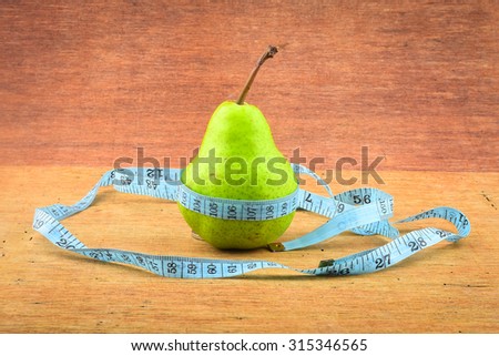 Pear with belt made from measuring tape - diet concepts