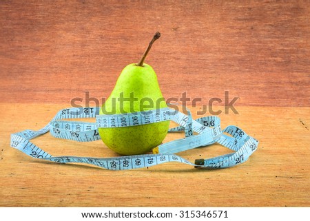 Pear with belt made from measuring tape - diet concepts