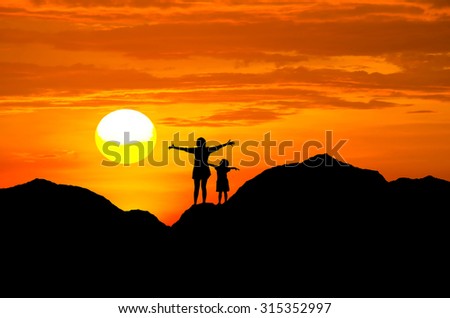 Silhouette mom and child freedom on sunset background