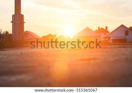 Little city or village in sunset or sunrise time. View from the level of asphalt