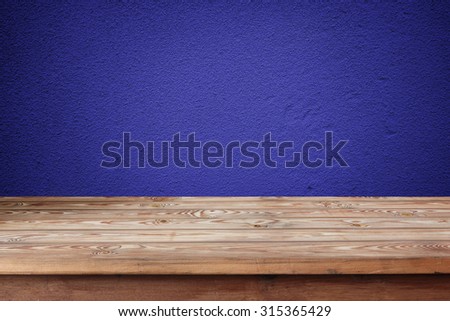 Empty wooden table against a blue wall. A template, a place for. Background, texture. Grunge texture.