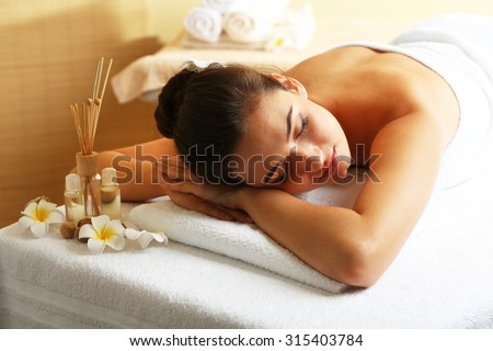 Young woman on massage table in beauty spa salon Royalty-Free Stock Photo #315403784