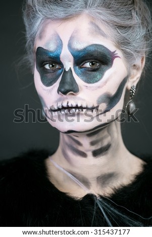 Studio art photo of the girl in the image of a skeleton on a black background