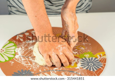 Man hands making dough for homemade dumplings with meat