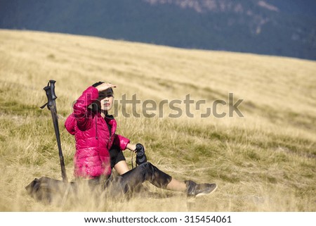 Hiker looking in binoculars enjoying spectacular view on mountain top
