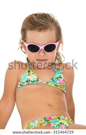 Adorable little girl in swimsuit and sunglasses tans in the sun-Isolated on white background