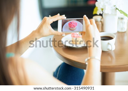 Point of view of a young woman taking a photo of her food with her smartphone. Picture of food on screen.