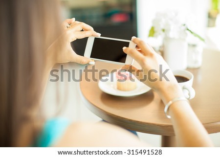 Point of view of a young woman taking a photo of her food with her smartphone. Blank screen