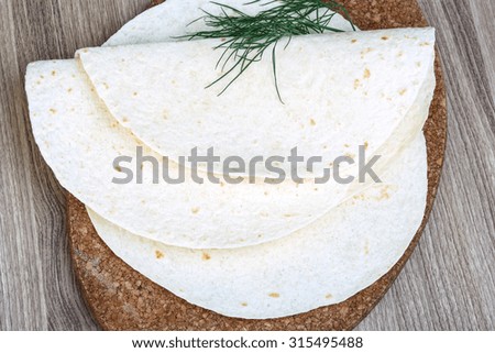 Mexican Tortillas with dill leaves on the wood background