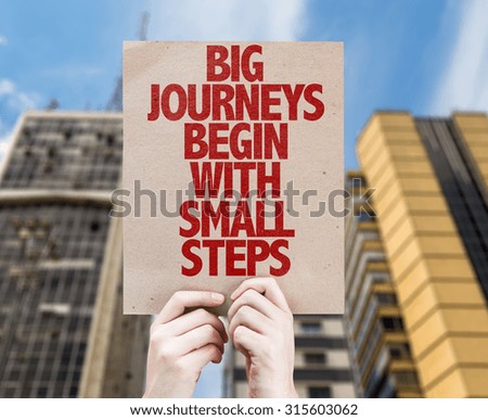 Big Journeys Begin With Small Steps cardboard with cityscape background