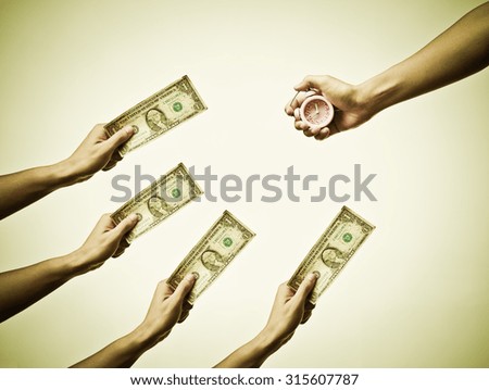 Buying time / hand holding a dollar banknote trying to buy a clock