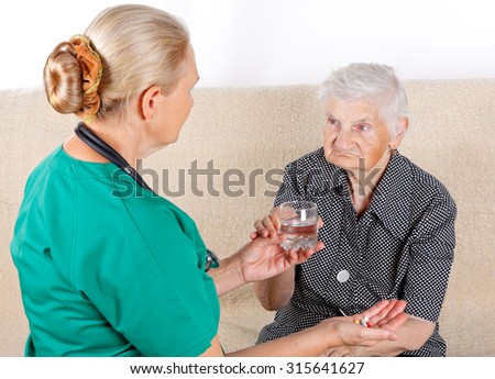 Female doctor helping a sick senior lady
