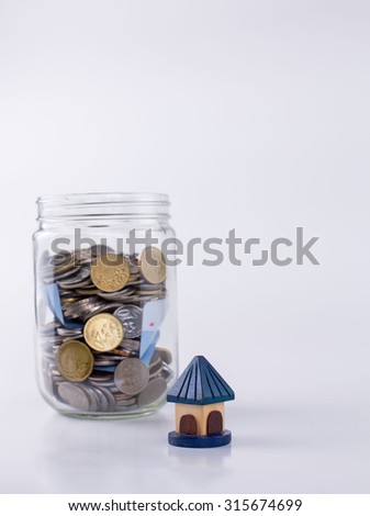 Small house model and jar full of coin(Ringgit Malaysia) on white background