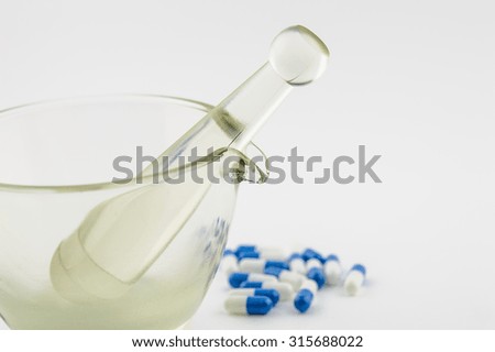Mortar and pharmacy blue and white capsules