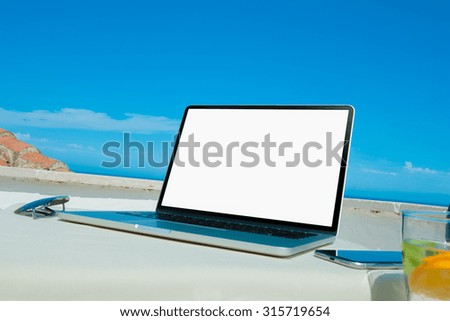 Laptop computer on wood table with sea background