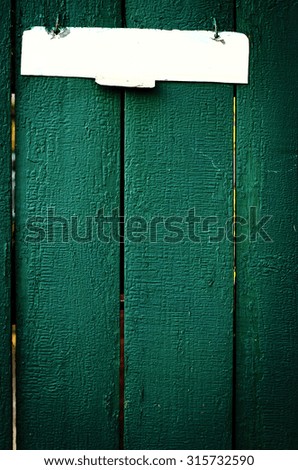 The old vintage wooden fence with metal sign, green colour