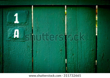 The old vintage wooden fence with metal sign, green colour