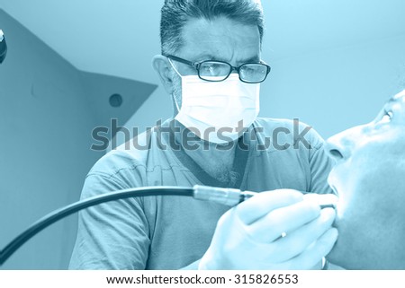 Dentist fixes the patient's teeth, Mending patient's teeth, Photography