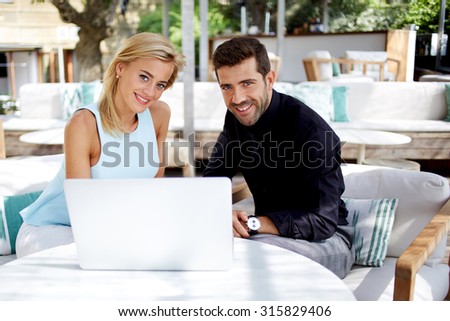 Businesswoman and businessman using laptop computer during work break in cafe,professional colleagues sit front open net-book at the restaurant table, cheerful entrepreneurs cooperating in new project