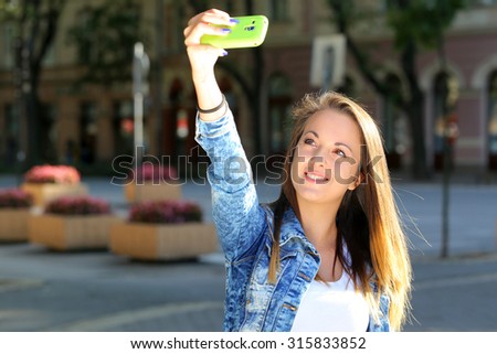 happy woman doing selfie on street