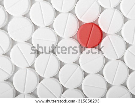 Top view of the heap of white medicine pills on white surface. One red medicine tablet is as a concept of a vaccine. Royalty-Free Stock Photo #315858293