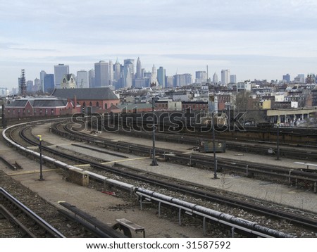 view of the skyline of New York City behind the tracks of the subway