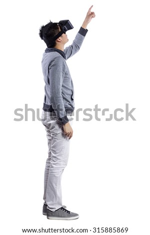 Male immersed in interactive virtual reality video game doing gestures on white background.  He is wearing a stereoscopic 3d vr headset.