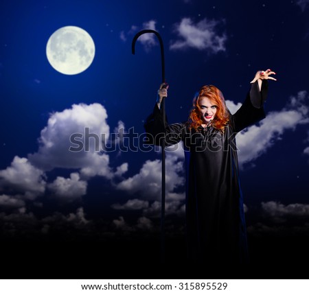 Young witch girl on night sky background