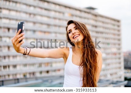 Young happy woman taking selfie on the rooftop