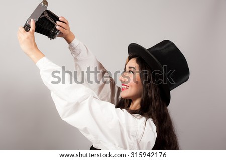 woman photographing herself on vintage camera