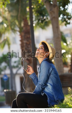 Portrait of a beautiful young woman listening to music on mobile phone