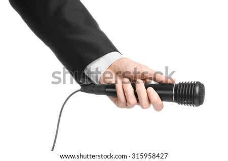 Business and speech topic: Man in black suit holding a black microphone isolated on white background in studio