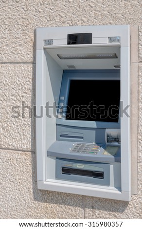 Cash machine in building wall with screen