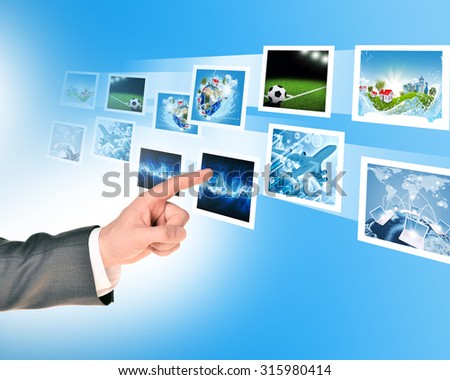 Businessmans finger pointing holographic pictures on abstract background
