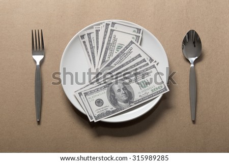 Many dollar on white dish with spoon and fork.