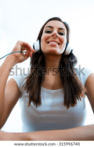 Portrait of a young beautiful woman listening to music with headphones