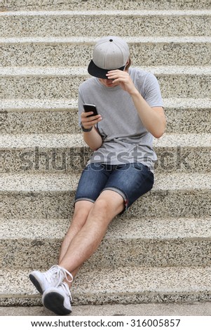 Teenage boy typing text message.Using smart phone