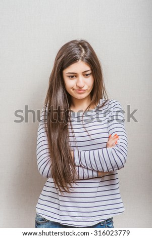 Young woman is standing and folding her arms on her chest.