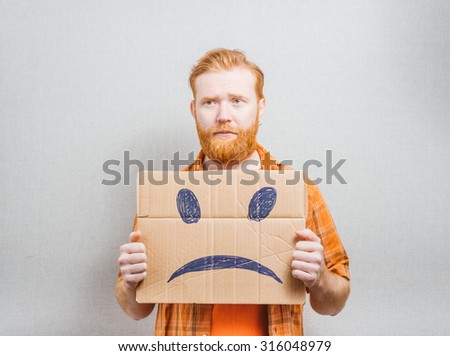 young man holding a picture of a sad