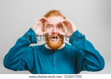 man  looking through hands, making binoculars