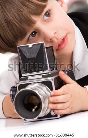 Attractive little boy with photo camera over white