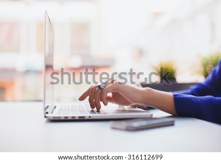 Close-up image of woman hands typing and writing massages on laptop,working on cafe.Overhead of essentials for modern young person.sensual woman reading and working,Urban Royalty-Free Stock Photo #316112699