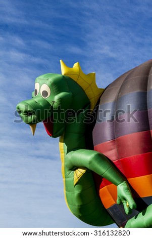 Hot air balloon with dragon shaped surrounding balloon on ground before take off