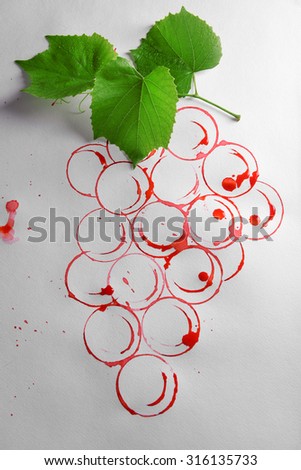 Grapes painted with red wine and cork isolated on white