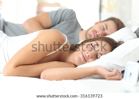 Happy couple sleeping in a comfortable bed at home Royalty-Free Stock Photo #316139723