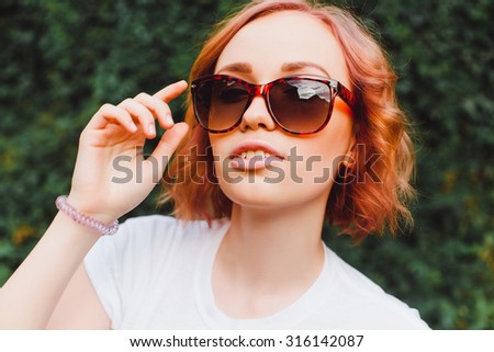 Smiling teen happy woman making selfie on the street, ling hairs, bright make up and cute clear glasses, traveling alone, having fun, positive mood, joy, vacation.Hipster outfit
