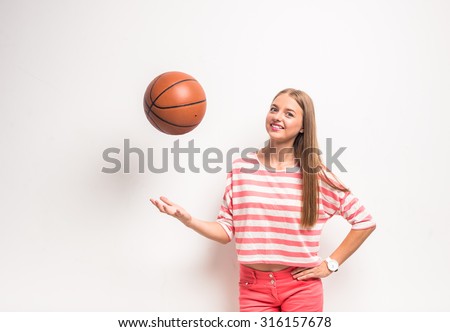 Young girl with a basketball, standing on white background.