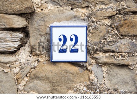 Ceramic number twenty two on the grey stone wall