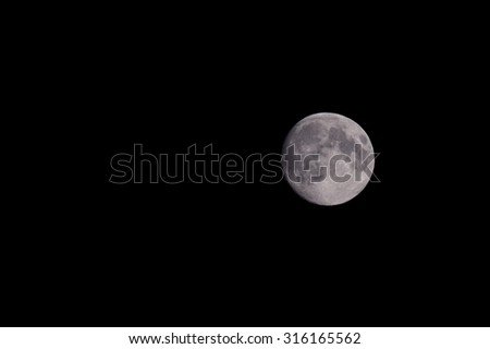 Closeup of beautiful silver full moon over dark black sky at night