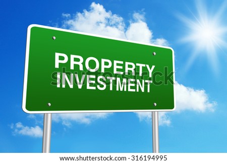 Green road sign with text Property investment is in front of the blue sunny background.